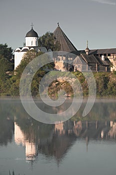 Ancient fortress towers and churches in the village of Staraya Ladoga in Russia, are reflected in the foggy Volkhov river on a