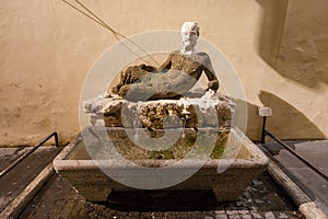 Ancient fountain Babuino with roman statue photo