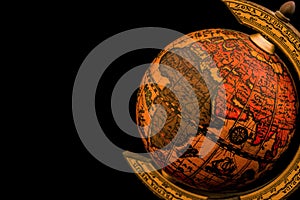Ancient globe replica with map of Asia, Europe, Africa and Indian Ocean and during the Age of Discovery on black background with