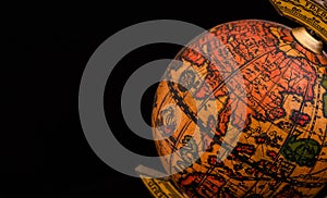 Ancient globe replica with map of East Asia countries on Eastern Hemisphere during the Age of Discovery on black background with