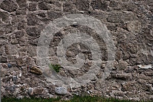 Ancient gloomy wall of gray stones, chaotic laying