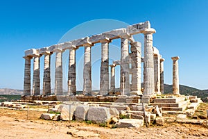 The ancient Greek Temple of Poseidon at Cape Sounion, doric columns and ruins on the hill with crystal blue sky background