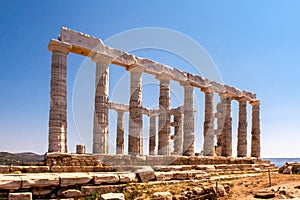 The ancient Greek Temple of Poseidon at Cape Sounion, doric columns and ruins on the hill with crystal blue sky background