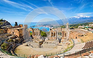 Ancient Greek theatre in Taormina on background of Etna Volcano, Italy