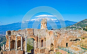 Ancient Greek theatre in Taormina on background of Etna Volcano, Italy