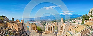 Ancient Greek theatre in Taormina on background of Etna Volcano, Italy photo