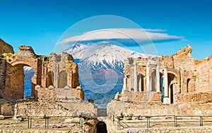 Ancient Greek theatre in Taormina on background of Etna Volcano, Italy