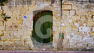 ancient green door with old wall. house number 39