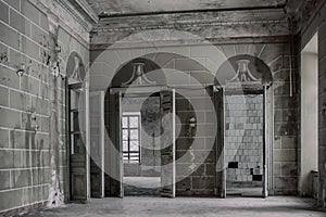 An ancient hall with wooden doors in an abandoned manor house.