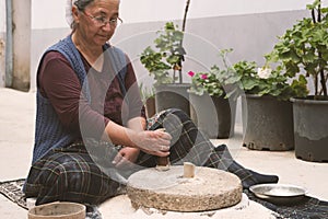 The ancient hand mill or quern stone, grinds the grain into flour.