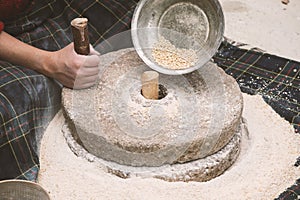 The ancient hand mill or quern stone, grinds the grain into flour.