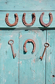 Ancient horseshoe and rusty key on wooden old door