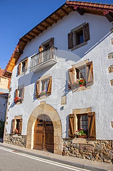 Ancient house with flowers. Big beautiful medieval building with arch doorway. Historic downtown.