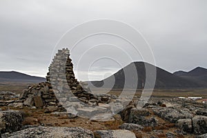 An ancient Inuit inukshuk inuksuk that serves as a landmark for travellers, located near Qikiqtarjuaq, Baffin Island