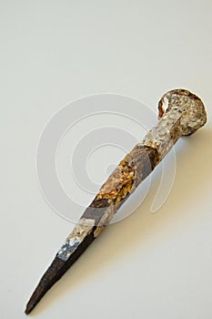 An ancient iron nail on white background
