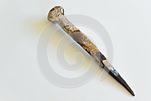 An ancient iron nail on white background