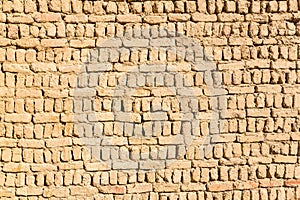 Ancient islamic Arabic muslim old town house wall built of yellow brown mud bricks texture. Al Qasr, Dakhla Oasis, Egypt.