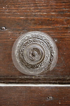 Ancient italian door handle on brown door