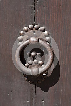 Ancient italian door handle on brown door