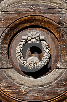 Ancient italian door handle on brown wooden background