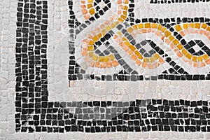 Ancient Italian Roman mosaic floor with geometric shapes composed of small colored stone tiles