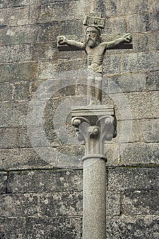 Ancient Jesus Christ sculpture on stone cross. Medieval architecture concept. Faith and suffering symbol. Religion background.