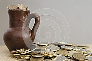 Ancient jug with coins. Old coins in a pot.