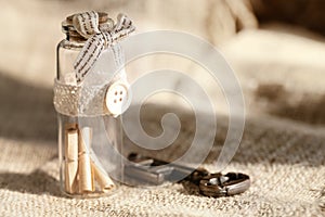 Ancient key and scroll message in the bottle with the white burlap background