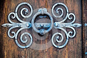 Ancient knocker on old wood door