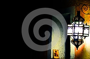 An ancient lamp illuminates the dark alley of the old market photo