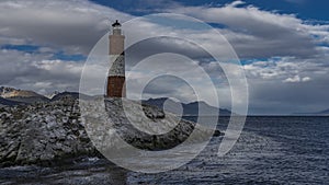 An ancient lighthouse stands on a rocky island in the Beagle Channel. photo