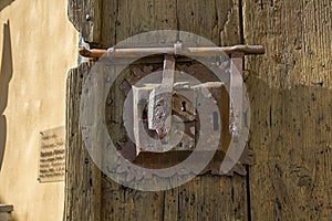 Ancient lock with latch on aged boarded door.