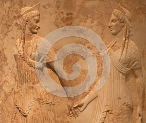 Ancient Greek bas-relief with two female figures, Nymphs or Graces holding hands and dancing photo