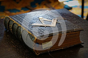 Ancient Masonic Holy Bible book with darkened pages and old bookmarks in dark brown leather cover with Square and photo