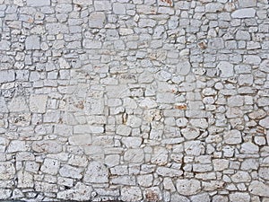 Ancient medieval stone masonry. Texture of a fragment of a wall of an old structure. A background for design and creative work.