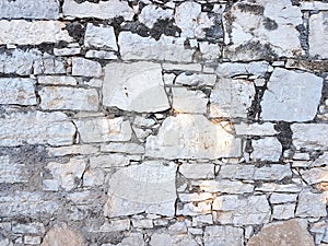 Ancient medieval stone masonry. Texture of a fragment of a wall of an old structure. A background for design and creative work.