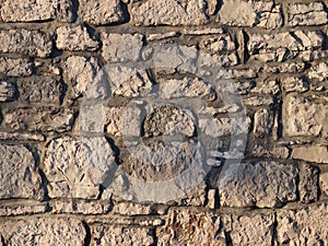 Ancient medieval stone masonry. Texture of a fragment of a wall of an old structure. A background for design and creative work.
