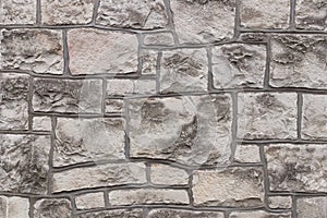 Ancient medieval stone masonry. Texture of a fragment of a wall of an old structure. A background for design and creative work. De