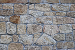 Ancient medieval stone masonry. Texture of a fragment of a wall of an old structure. A background for design and creative work. De