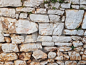 Ancient medieval stone masonry. Texture of a fragment of a wall of an old structure. A background for design and creative work. De