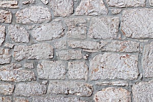 Ancient medieval stone masonry. Texture of a fragment of a wall of an old structure. A background for design and creative work. De