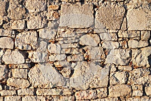 Ancient medieval stone masonry. Texture of a fragment of a wall of an old structure. A background for design and creative work. De