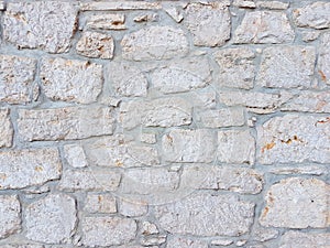 Ancient medieval stone masonry. Texture of a fragment of a wall of an old structure. A background for design and creative work. De