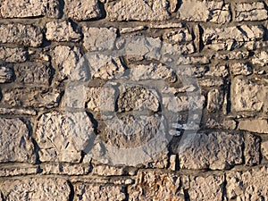 Ancient medieval stone masonry. Texture of a fragment of a wall of an old structure. A background for design and creative work. De