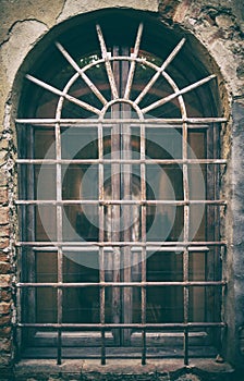 Ancient medieval window with wrought iron bars