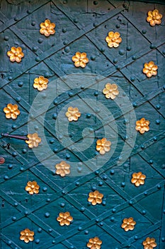 Ancient metal door with rivetsand golden flowers