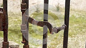 Ancient metal rusty wrought handle deadbolt of the door of the lattice gate of the antique cathedral