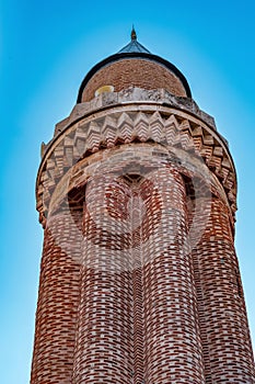 Ancient minaret with loudspeakers against the sky