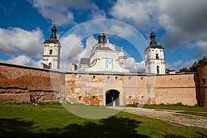 Ancient monastery of Discalced Carmelites, cathedral and fortress wall on background of blue cloudy sky. Berdychiv, Ukraine. Tour