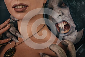 Ancient monster vampire demon bites a woman neck. Halloween fantasy